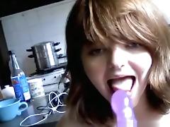 Brunette girl sucks a vibrator, masturbates in the kitchen and squirts.