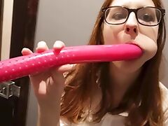 Lady with glasses plays with a dildo.